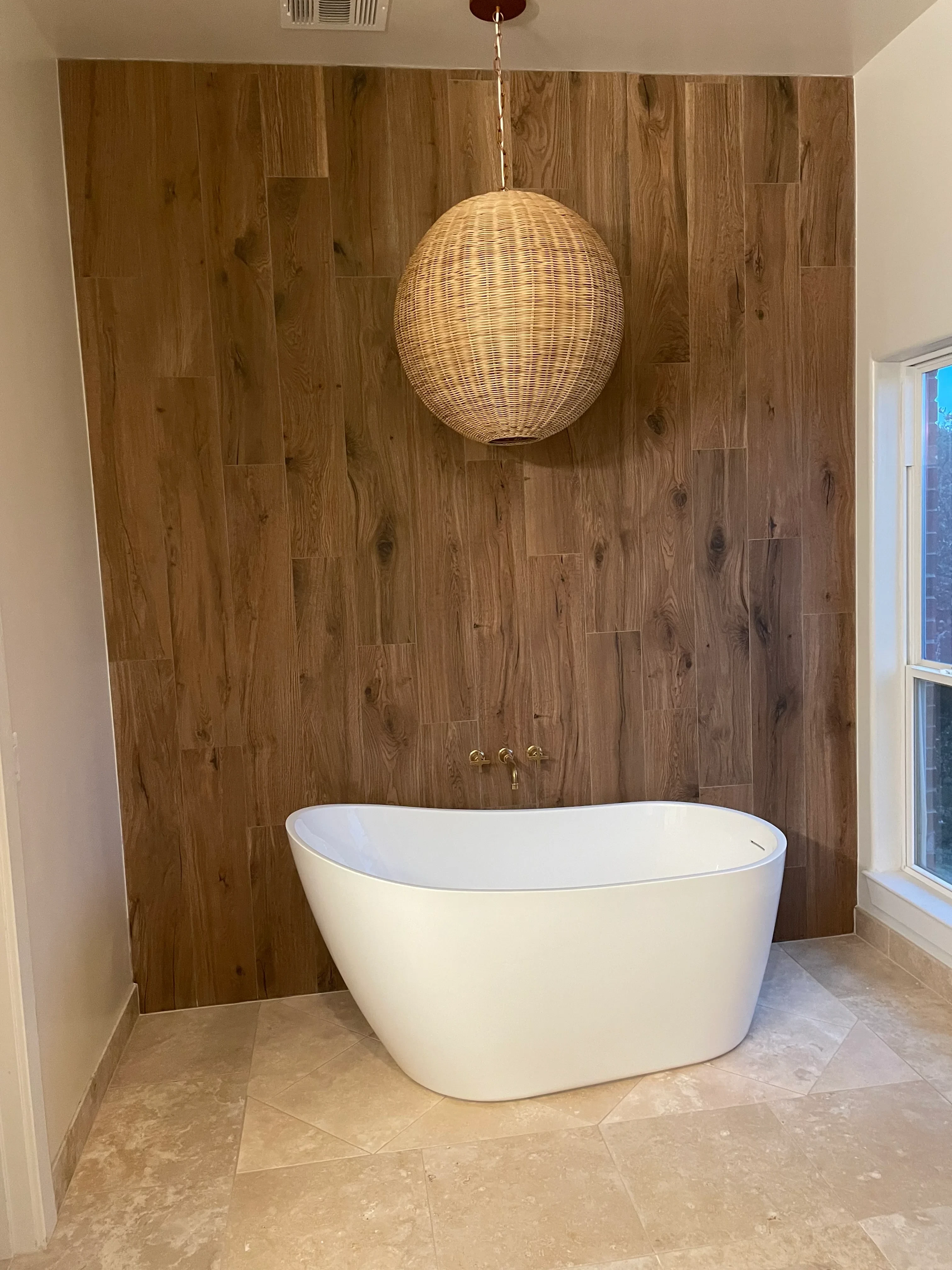 Bathroom with engineered hardwood flooring and natural stone tile walls