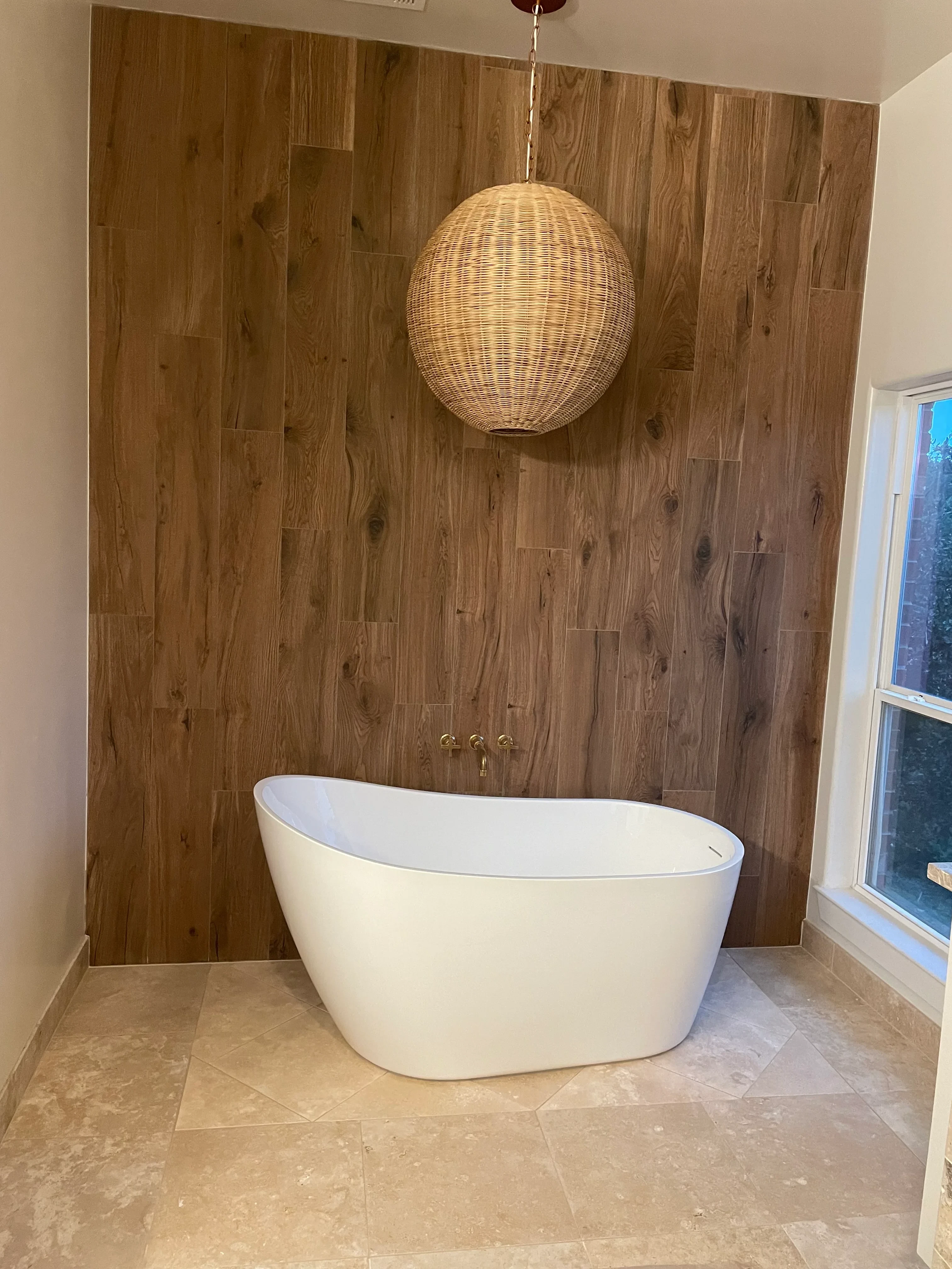 Bathroom with wide-plank wood flooring, stone tile, skylight, and modern white fixtures