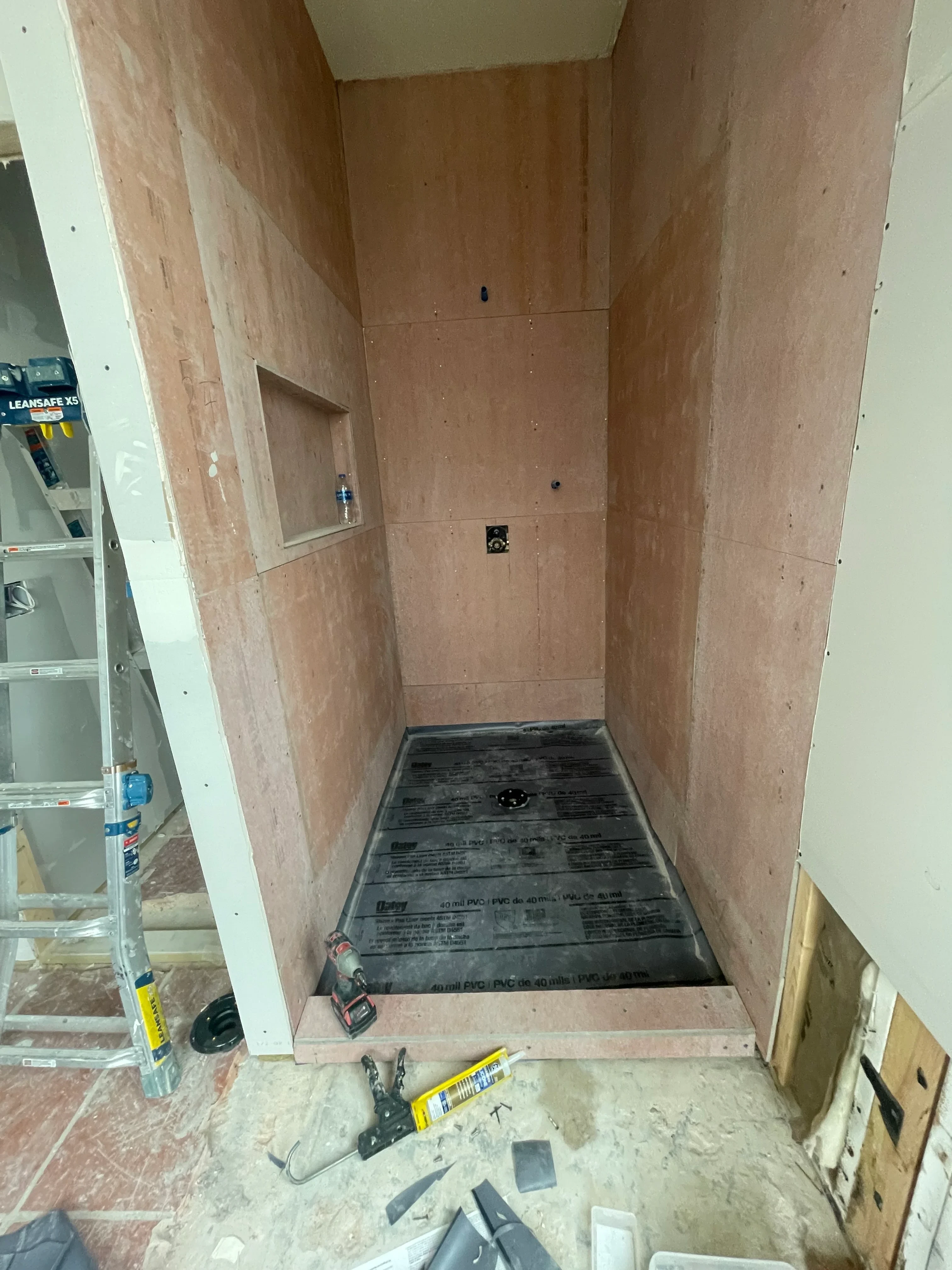 Drywall and framing installation with plywood flooring and electrical rough-in work in progress