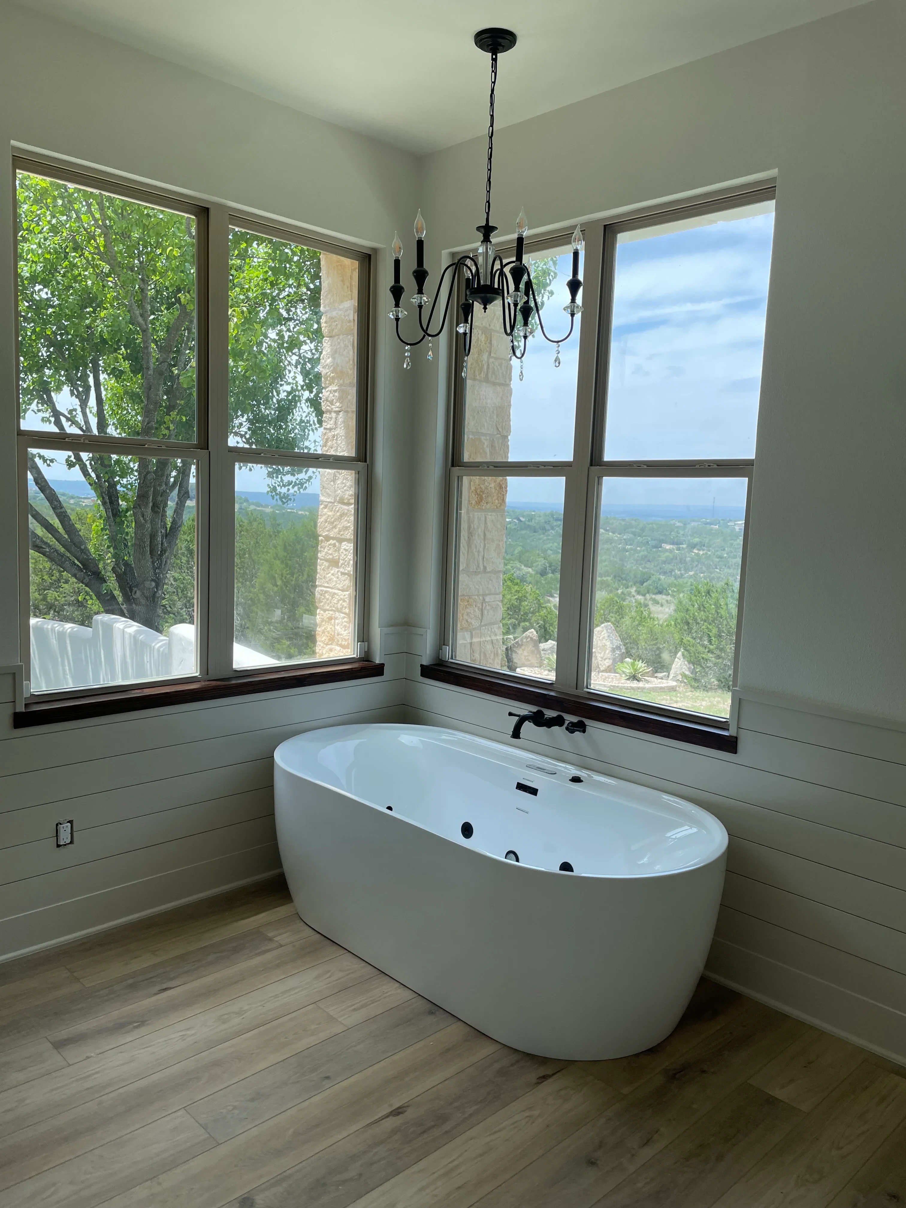 Aluminum-framed skylight and multi-pane windows installed in residential interior with wood flooring